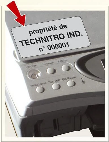 Étiquette de propriété argent numérotée posée sur un appareil électronique