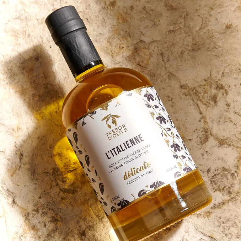 Bouteille d'huile d'olive habillée d'une étiquette personnalisée, posée sur une pierre claire